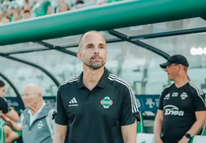 Trener Radomiaka w czarnej koszulce z herbem klubu, skupiony na boisku.