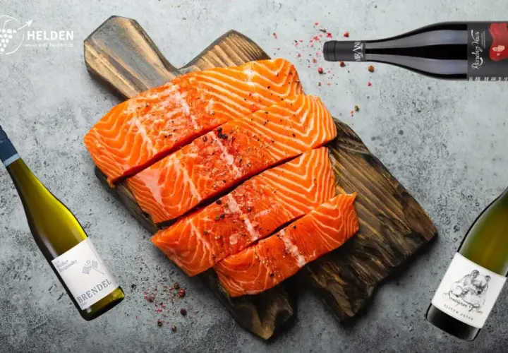 Frischer Lachs auf Holzbrett, daneben Weißwein und Rotwein. Die Frage: welcher Wein zu Lachs? Hier finden Sie die Antwort.