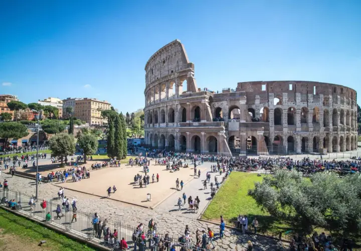 Le Colisée d'Italie, monument emblématique, accueille une foule de visiteurs sous un ciel bleu éclatant.