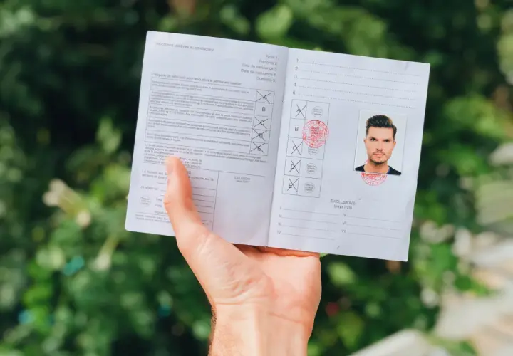 Międzynarodowe prawo jazdy z fotografią mężczyzny. Dokument zawiera informacje o kategoriach pojazdów i wykluczeniach.