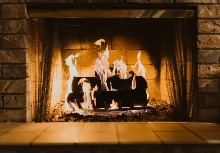 Un feu de cheminée crépite joyeusement, ses flammes dansantes projetant des signes chaleureux sur les briques.