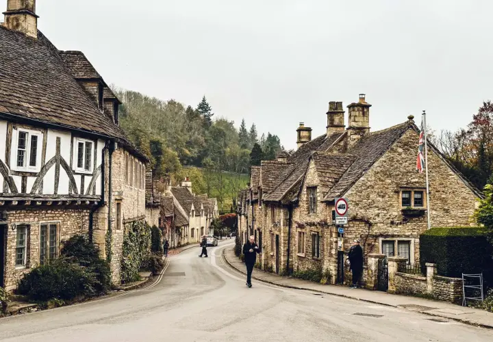 Kamienna uliczka w Cotswolds, z tradycyjnymi domami i zielenią.