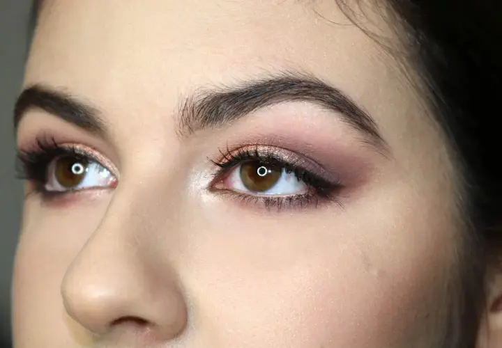 Occhi marroni con makeup sfumato sui toni del rosa e del bronzo, che ne esaltano la forma. Ciglia lunghe e folte.