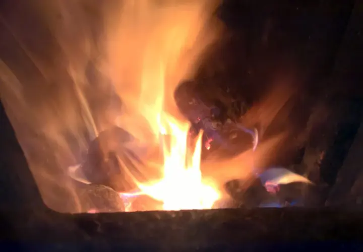 Jasne płomienie tańczą wokół żarzących się brykietów ze słomy, tworząc ciepłą, przytulną atmosferę.