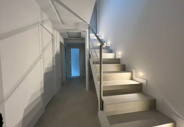 Iluminación peldaños escalera moderna, con luces empotradas que guían el camino.