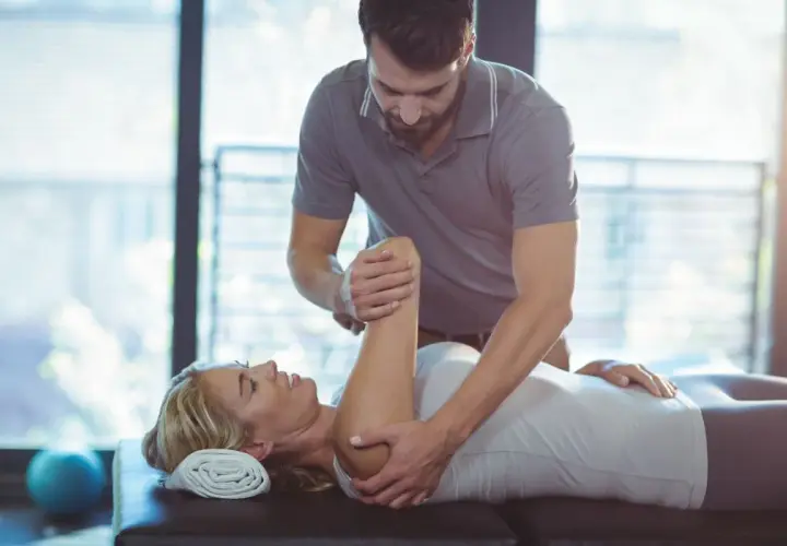 Fizjoterapeuta wykonuje ćwiczenia z pacjentką. Rehabilitacja i fizjoterapia pomagają w powrocie do zdrowia.