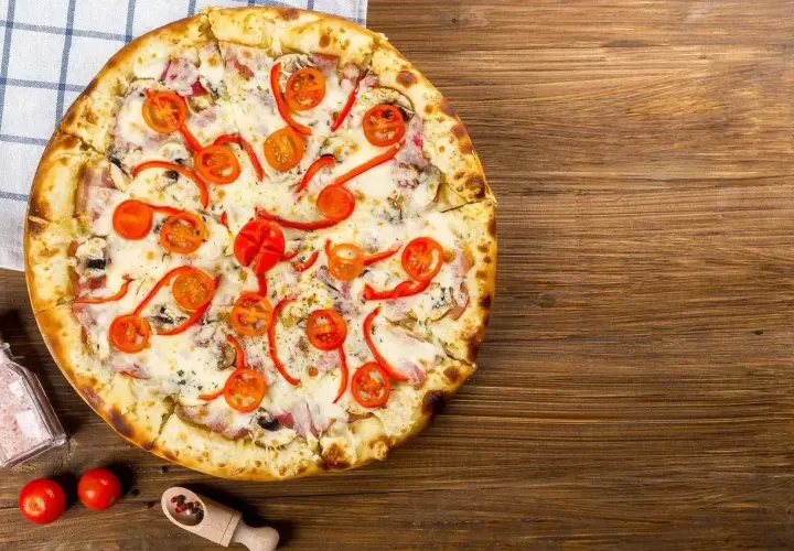 Pyszna pizza z pomidorkami i papryką, idealna na Pizza Hut promocje w lokalu.