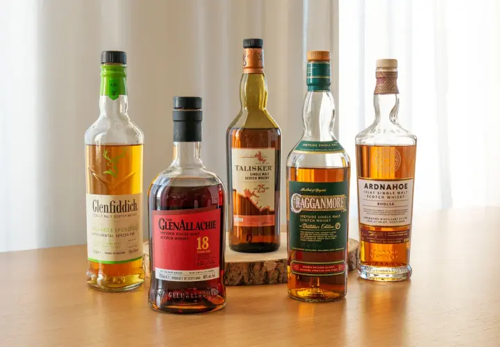 Fünf Flaschen verschiedener Whisky-Sorten stehen nebeneinander: Glenfiddich, Glenallachie, Talisker, Cragganmore und Ardnahoe.