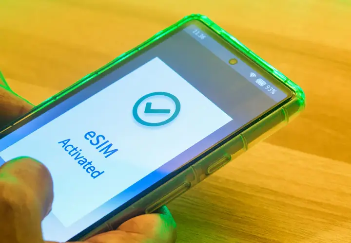 Smartfon z zieloną obudową pokazuje komunikat "eSIM Activated" i zielony znaczek. Tak działa esim.