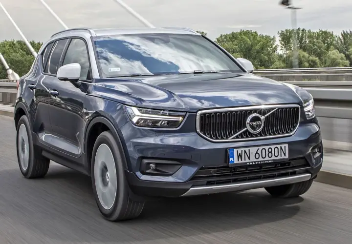 Ciemnoszary Volvo XC40 jedzie po moście. Sprawdź aktualną volvo xc40 cena i dostępne wersje.