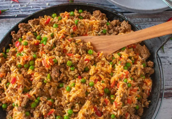 Herzhafte hackfleisch reis pfanne mit Erbsen und Paprika, garniert mit Chilischoten. Ein köstliches Gericht für die ganze Familie.