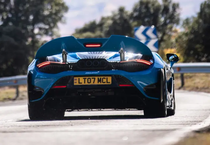Niebieski McLaren 765LT z czterema końcówkami wydechu pędzi po zakręcie.