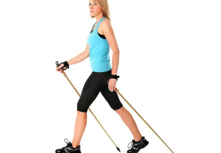 Kobieta ćwiczy nordic walking, pokazując, jak dobrać kije.