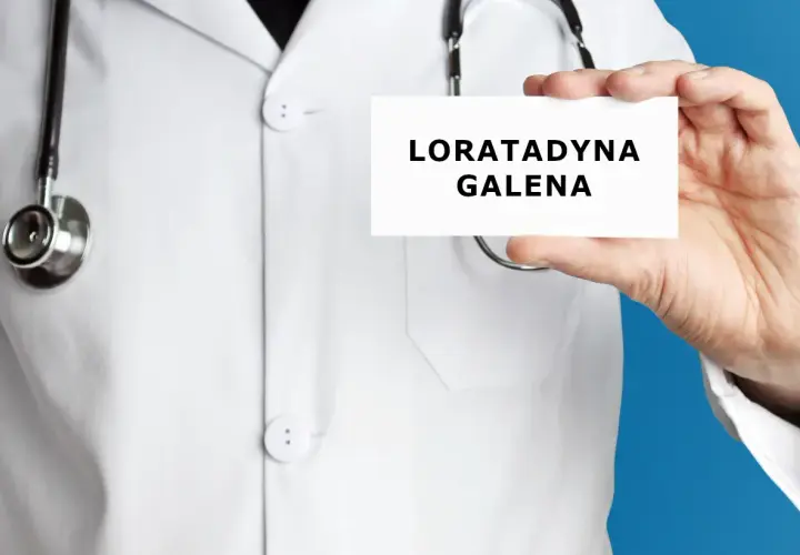 Lekarz trzyma kartkę z napisem "LORATADYNA GALENA". Stetoskop wisi na jego białej katanie.