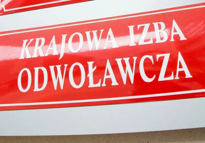 Czerwona tablica z białym napisem "KRAJOWA IZBA ODWOŁAWCZA".