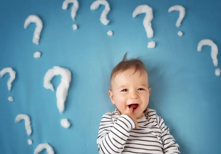 Un neonato sorridente con tante domande intorno. Quante volte fa la cacca un neonato di 1 mese?
