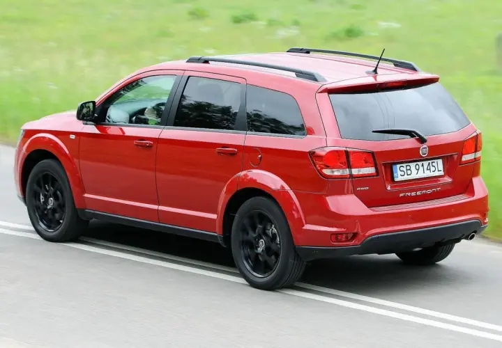 Czerwony Fiat Freemont na drodze. Wiele osób szuka fiat freemont opinie przed zakupem.