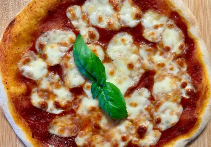 Eine köstliche italienische Sauerteig Pizza Margherita mit geschmolzenem Mozzarella und frischem Basilikum.