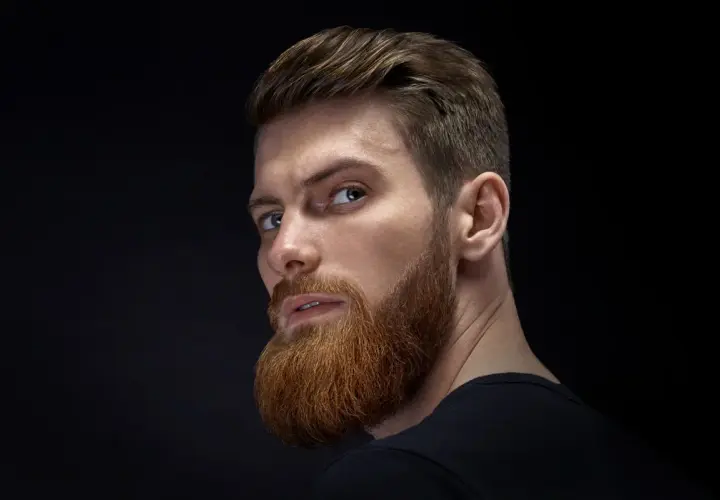 Hombre con barba y peinado moderno, ejemplo de cortes de pelo hombre elegante.