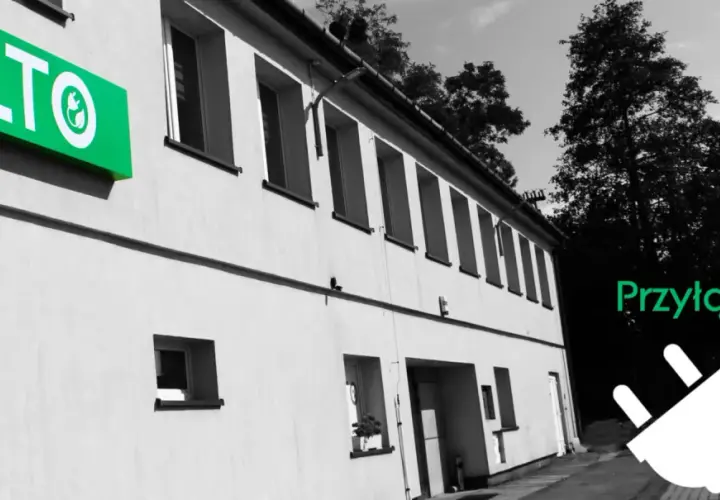 Hurtownia elektryczna ELTO zaprasza do przyłączenia się. Zielone logo ELTO na budynku i wtyczka symbolizują energię.