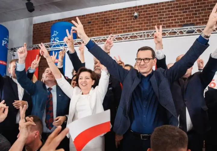 Radosny tłum z polskimi flagami i znakami zwycięstwa. W centrum Mateusz Morawiecki i inni politycy PiS, być może świętujący sukces, mimo że lista afer PiS jest długa.