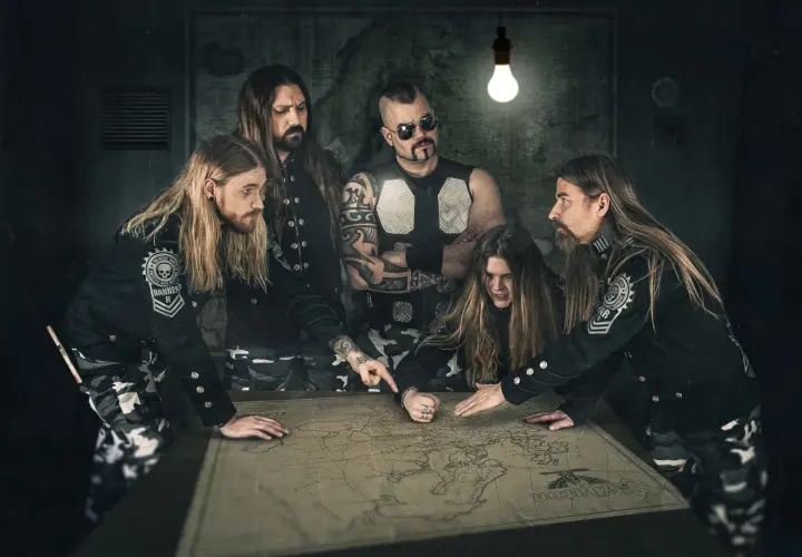 Zespół Sabaton, niczym skrzydlaci husarze, planuje strategię na mapie.