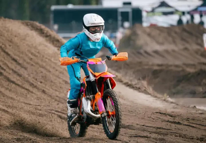 Piloto en moto 50cc azul y naranja compite en circuito de tierra. ¡Sorprende cuanto corre una 50cc!