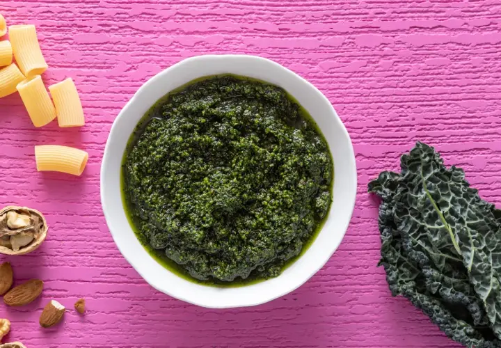 Pesto di cavolo nero crudo, ricco e vibrante, pronto per condire la pasta. Noci e mandorle completano gli ingredienti.
