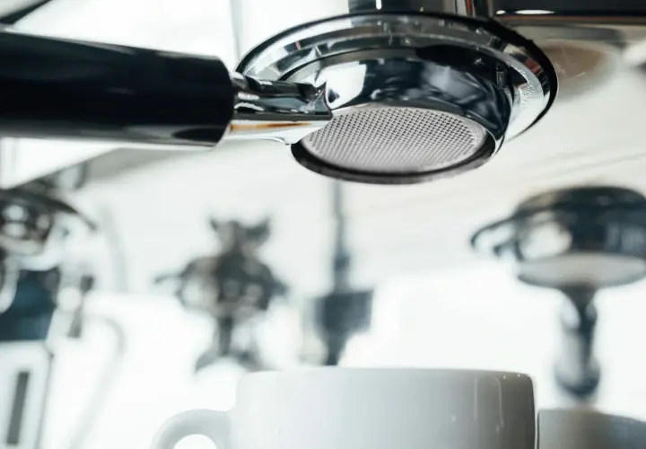 Filtr ekspresu DeLonghi, biała filiżanka i inne elementy. Zbyt częste odkamienianie ekspresu Delonghi może prowadzić do jego uszkodzenia.