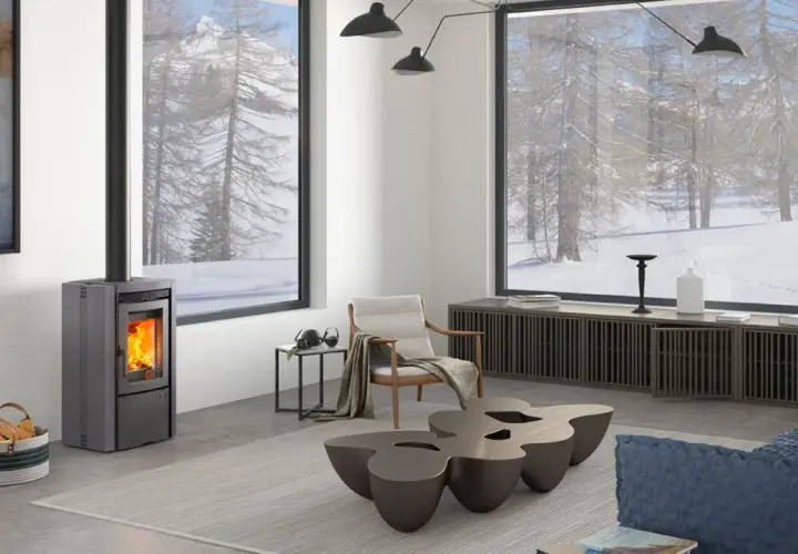 Estufa de pellets moderna en un salón acogedor con vistas nevadas. ¿Qué tipo de estufa es mejor para crear este ambiente cálido?