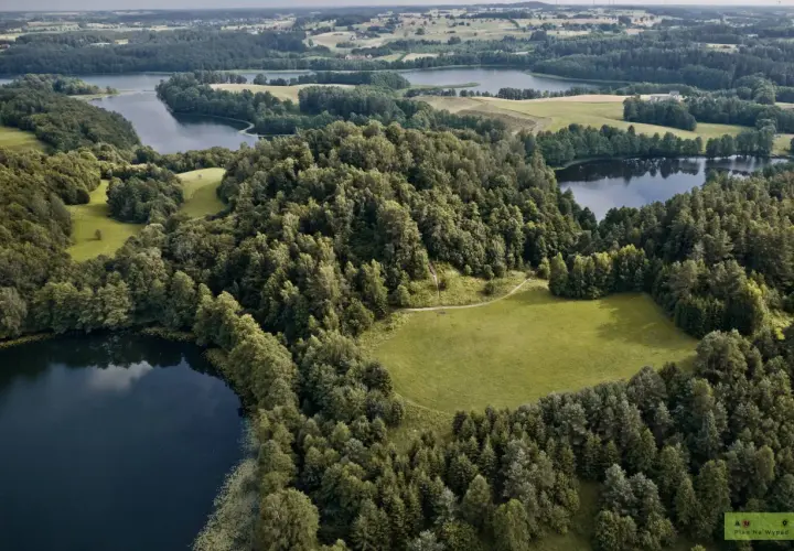 Malownicze jeziora i lasy tworzą magiczne miejsca na Podlasiu. Widok z lotu ptaka na zielone wzgórza i spokojne wody.