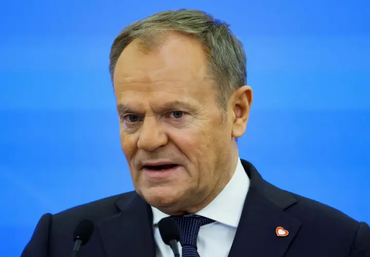 Donald Tusk, w garniturze i z serduszkiem na klapie, przemawia. Zastanawiamy się, co zrobił Tusk dla Polski.