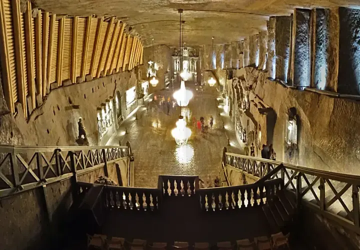 Wieliczka wycieczka: podziemna kaplica z kryształowymi żyrandolami i rzeźbami w soli. Widok z góry na schody i balustrady.