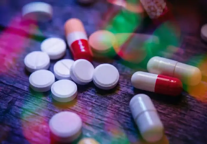 Pastiglie e capsule colorate su un tavolo di legno. L'aripiprazolo a cosa serve? Aiuta a trattare disturbi come schizofrenia e disturbo bipolare.