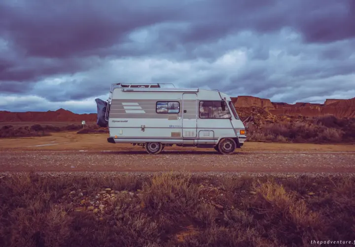 Camping-car Hymer B544, prêt pour l'aventure dans un paysage désertique sous un ciel orageux.
