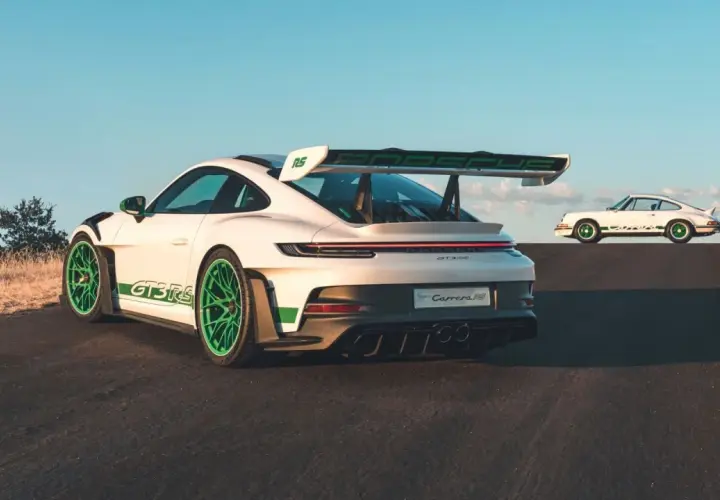 Zwei weiße Porsche 992 GT3 RS mit grünen Akzenten, einer im Vordergrund, der andere im Hintergrund, der an den Carrera RS erinnert.