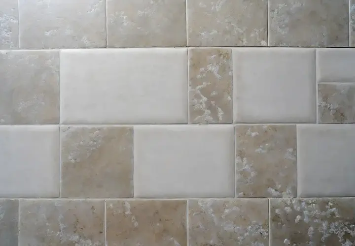 Pareti con piastrelle rettificate e fuga minima. Diverse tonalità di beige e bianco creano un motivo moderno e pulito.