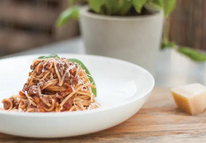Pyszne spaghetti z sosem ragu, posypane parmezanem. Idealny przepis na obiad.
