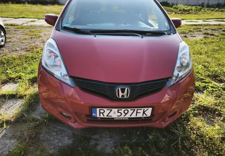 Czerwona Honda Jazz z tablicą RZ 597FK. Zastanawiasz się, jaki olej do Hondy Jazz 1.4 benzyna? Ten model zasługuje na najlepszy!