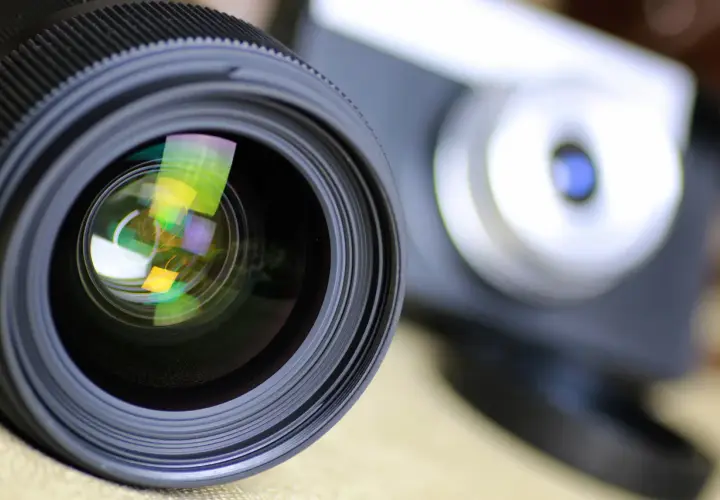 Obiektyw aparatu z widocznymi odbiciami, gotowy do uchwycenia wyjątkowych chwil. To symbol akredytacji fotograficznej.