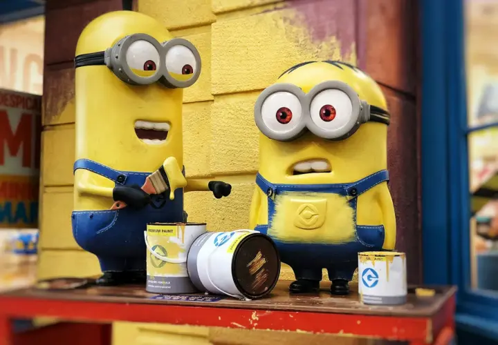 Dwa Minionki malują pędzlem. Jeden z nich ma otwarte usta, drugi wygląda na zaskoczonego. To inspiracja, jak zrobić strój Minionka!