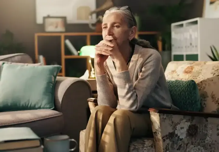 Une femme âgée, le regard perdu, semble réfléchir aux changements de la ménopause et à la dépression qui peut l'accompagner.