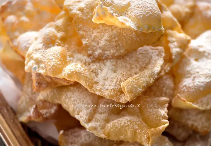 Chiacchiere croccanti, una deliziosa chiacchiere ricetta della nonna, cosparse di zucchero a velo.