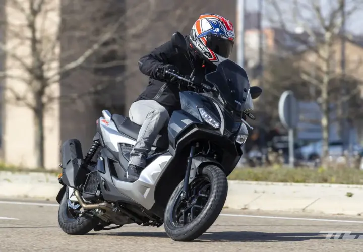 Motorista con casco a bordo de una Aprilia SR GT 125, lista para alcanzar su velocidad máxima en la carretera.
