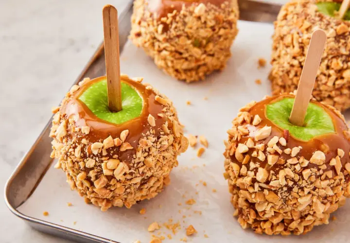 Manzanas acarameladas cubiertas de cacahuetes, perfectas para recetas con manzanas.