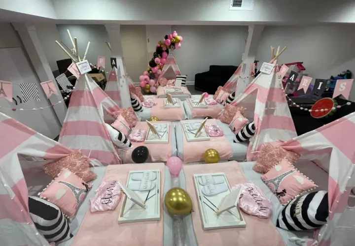 Urocze namioty tipi w różowo-białe paski, poduszki z Wieżą Eiffla i balony tworzą magiczne **pomysły na nocowanie** dla dziewczynek.