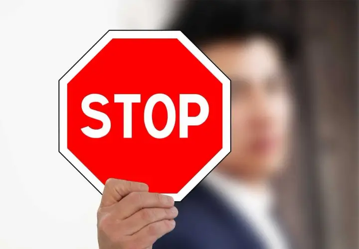 Mężczyzna trzyma czerwony znak stop.