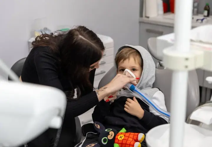 Chłopiec w masce znieczulającej u dentysty. Po zabiegu nie można jeść, by uniknąć zadławienia.