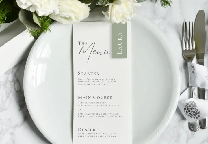 Le menu de mariage de Laura, avec des fleurs blanches et une présentation élégante.