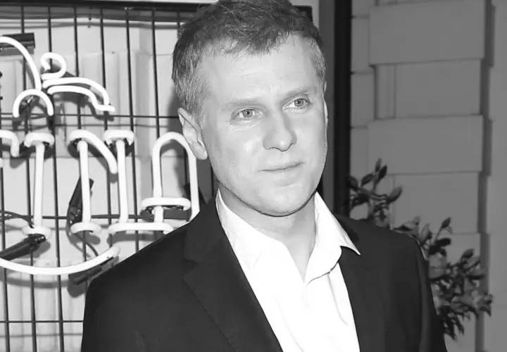 Krzysztof Reszpondek, znany z walki z chorobą, na tle neonowego napisu.